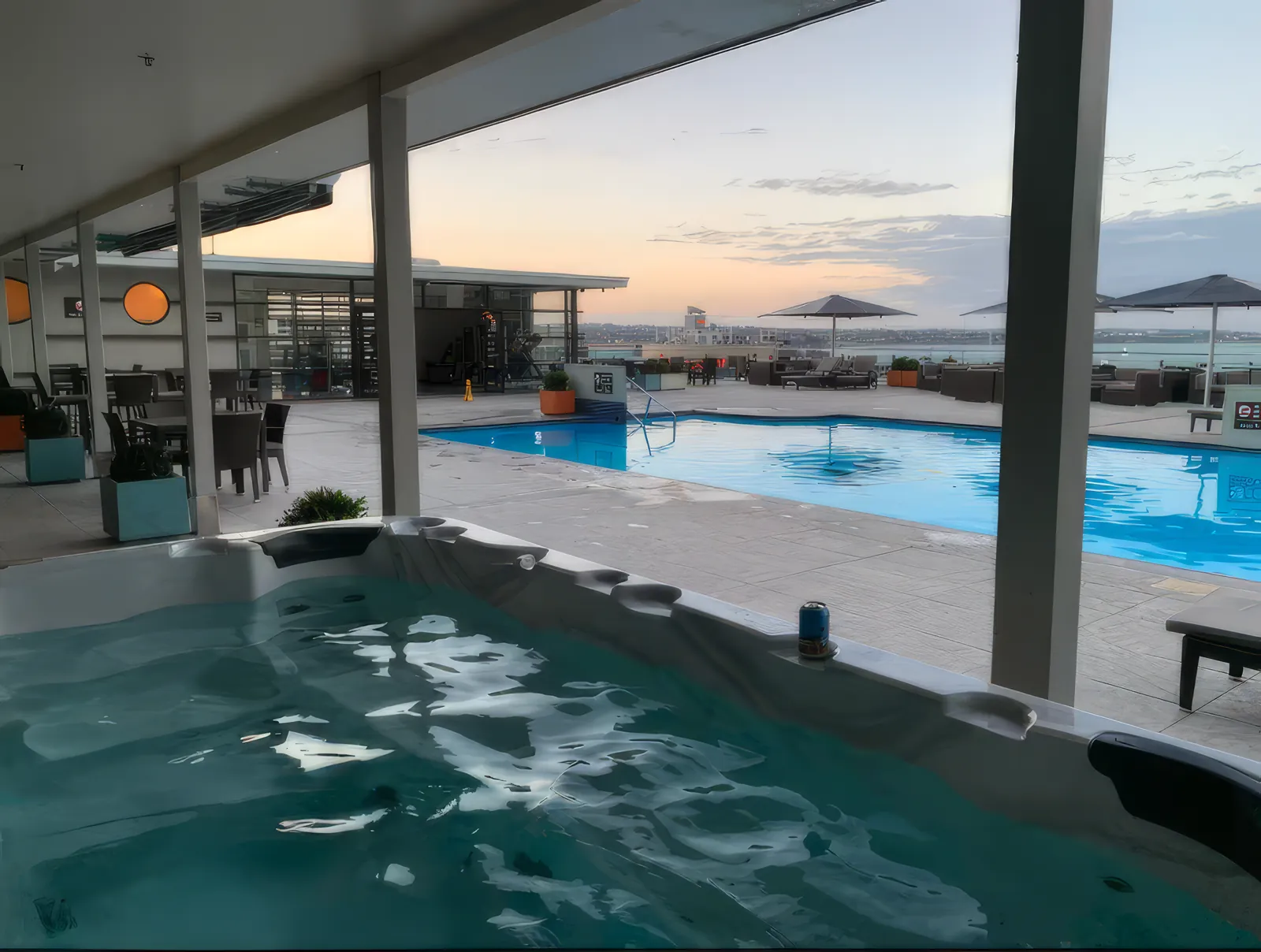 The rooftop pool and spa at dusk, looking out over Auckland's harbour